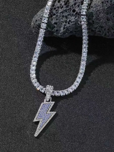 Macro shot of silver tennis chain with purple and white lightning bolt pendant