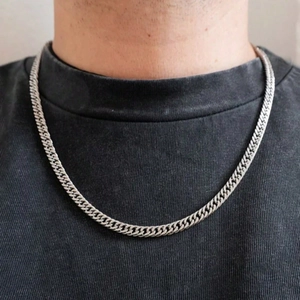 Gros plan d'une chaîne gourmette argentée sur un mannequin homme avec un t-shirt gris
