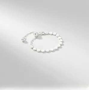 Macro detail of S925 sterling silver beaded chain ring with adjustable ball pendant