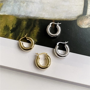 Close-up of gold and silver S925 sterling silver hoop earrings with polished finish