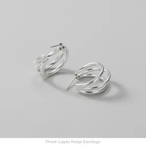Detailed view of S925 sterling silver triple-layer curved hoop earrings with polished finish
