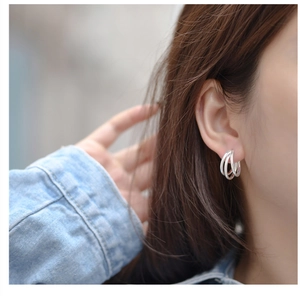 Close-up of minimalist S925 sterling silver triple-layered hoop earrings on model