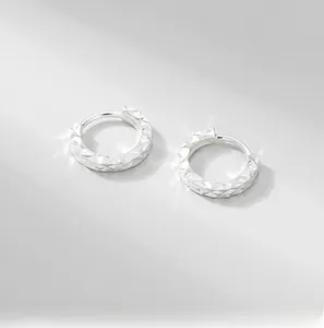 Close-up of S925 silver hoop earrings with textured diamond-cut finish and sparkling metallic texture
