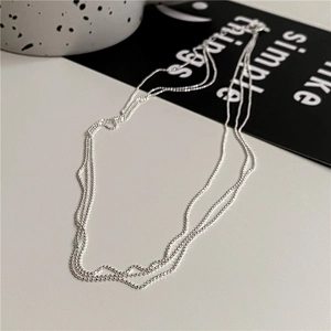 Collier à trois rangs en argent sterling S925 avec perles sur fond au style minimaliste