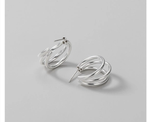 Macro shot of minimalist S925 sterling silver triple-layer curved stud earrings in silver