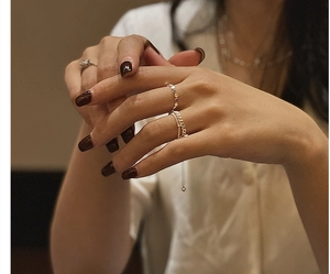 Detail of stacked S925 sterling silver beaded rings with gold finish on a finger