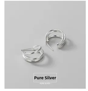 Detailed view of triple-layered spiral S925 sterling silver stud earrings in silver finish
