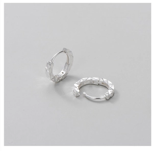 Close-up of S925 sterling silver hoop earrings with diamond-cut faceted texture