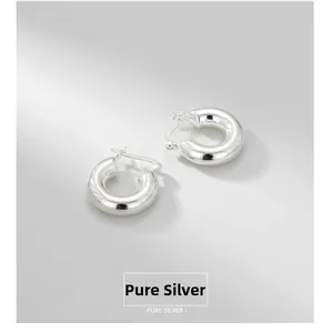 Macro view of chunky S925 sterling silver hoop earrings with polished finish and hallmark