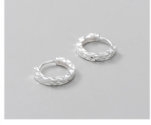 Macro shot of S925 sterling silver hoop earrings with geometric diamond-cut facets