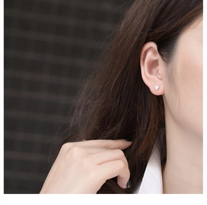 Close-up of minimalist S925 sterling silver meteorite stud earring on a model ear