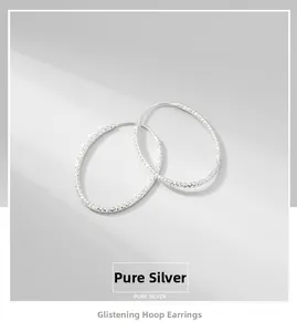 Detailed macro view of S925 sterling silver hoop earrings with textured diamond-cut finish