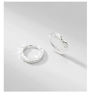 Detailed view of diamond-cut S925 sterling silver hoop earrings with sparkling texture