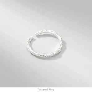 Macro view of adjustable silver ring with irregular hammered texture and matte finish