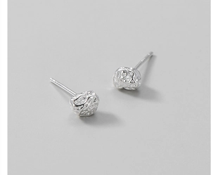 Macro detail of S925 sterling silver stud earrings with irregular meteorite texture