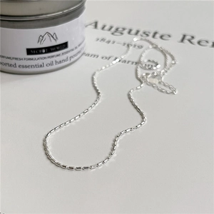 Minimalist S925 sterling silver beaded chain necklace displayed on a white art-style backdrop