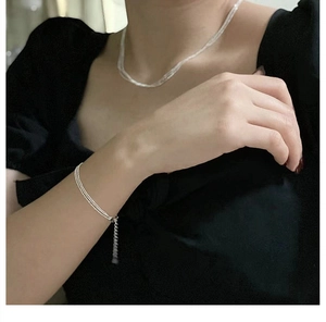Close-up of sparkling S925 silver triple-layered beaded bracelet and sleek snake chain