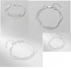 Detailed macro view of S925 sterling silver triple-layered beaded bracelet with lobster clasp