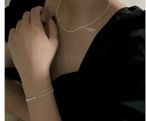 Détail de colliers superposés en argent S925 étincelant portés par une femme mannequin