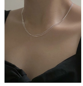 Gros plan d'un collier à trois rangs en argent sterling S925 sur le cou d'un mannequin