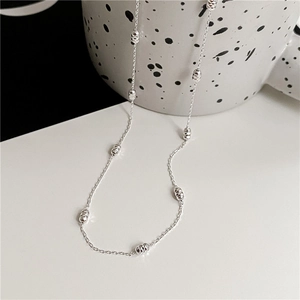 Detail of S925 sterling silver chain with sparkling textured beads against a white background