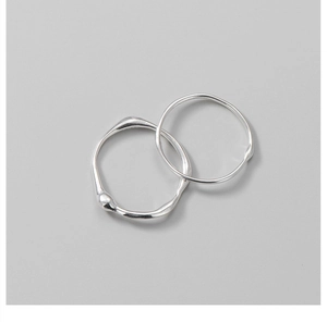 Detailed view of silver rings featuring irregular liquid-like textures and polished finishes
