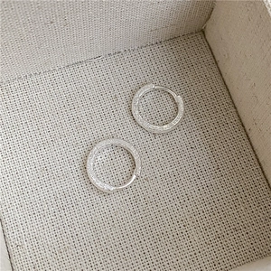 Macro detail of S925 sterling silver hoop earrings with sandblasted frosted texture