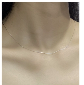 Nahaufnahme einer minimalistischen S925 Sterlingsilberkette am Hals getragen