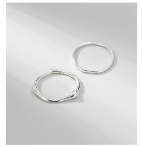 Macro detail of S925 sterling silver rings with irregular lava texture and liquid lines