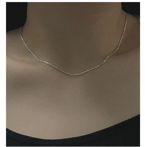 Detail of S925 sterling silver beaded necklace with iridescent cube charms on model