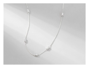 Macro detail of S925 sterling silver chain with textured cylindrical beads and subtle glow