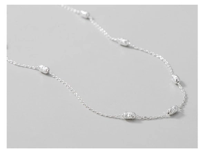 Macro detail of S925 sterling silver chain with textured cylindrical beads necklace