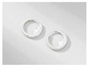 Macro shot of S925 sterling silver huggie earrings with a fine sandblasted glitter finish