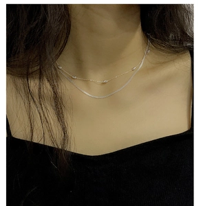 Close-up of layered S925 sterling silver beaded necklace on a model for a chic look
