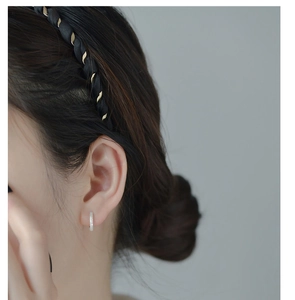 Close-up of sparkling S925 sterling silver hoop earring worn by a model in soft lighting