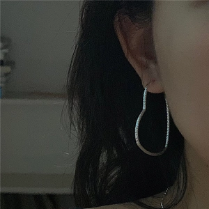 Sparkling S925 sterling silver heart-shaped large hoop earrings worn by a model