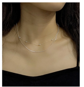 Close-up of S925 sterling silver double-layer clavicle chain with beaded accents on model