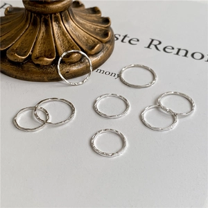 Detailed view of seven stacked S925 sterling silver hammered rings with unique texture