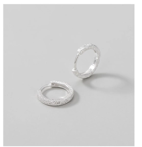 Close-up of S925 sterling silver hoop earrings with a sparkling sandblasted finish texture