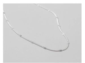 Macro shot of S925 sterling silver curb chain with polished sparkling round disc charms