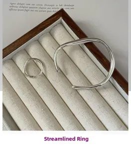 Detail of silver liquid streamline ring and open cuff bracelet in a premium velvet box