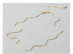 Detail of thin S925 sterling silver gold chain with delicate heart pendant and extender