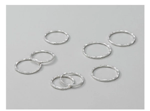 Detailed view of eight S925 sterling silver rings with hammered texture and hallmarks