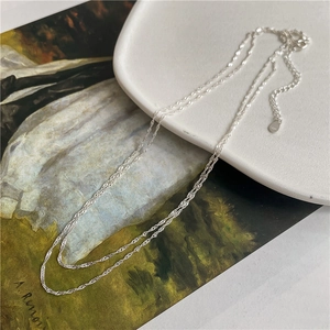 Macro detail of a double-layered S925 sterling silver chain with a lobster clasp