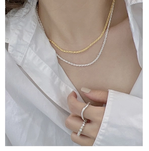 Close-up of stacked S925 sterling silver liquid rings and mixed metal rope necklaces