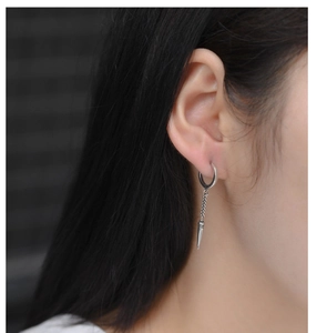 Detail shot of 925 silver punk style earring with a chain and triangular spike pendant