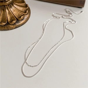 Close-up of a shimmering S925 sterling silver Chopin chain necklace with double-layer texture