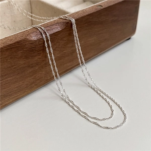 Close-up of double layered S925 sterling silver water ripple chain on a wooden box