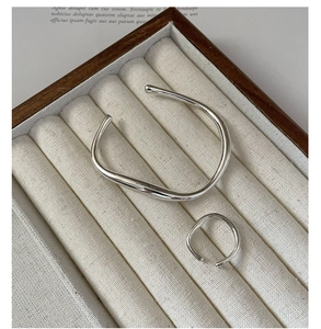 Detail of silver liquid streamline bangle and ring in a velvet jewelry display box