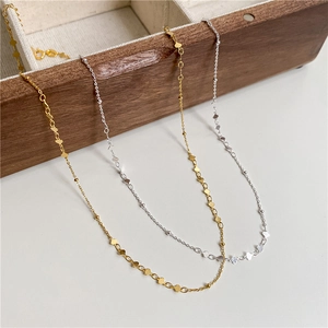 Minimalist S925 sterling silver clavicle necklace with small heart charms displayed on wood